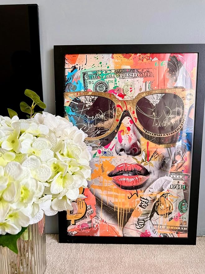 Tableau Spectre Urbain encadré sur un tapis avec bouquet de fleurs blanches à gauche : portrait graffiti multicolore de femme en cadre noir, style street art